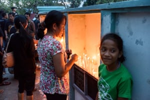 After a late afternoon mass on Good Friday, hundreds of locals gather in a nearby cemetery to light candles and pray for their deceased relatives.