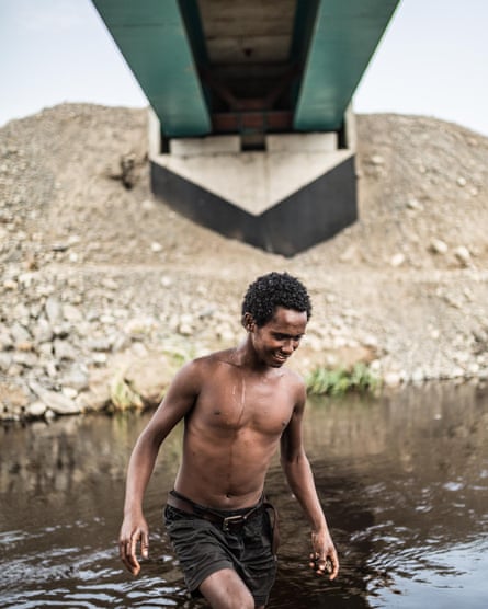 Ibrahim, 17, swims in the river beneath new tracks being built by a Turkish construction company in Awash National Park.