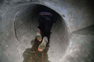 A protester crawls into a sewer in Hong Kong