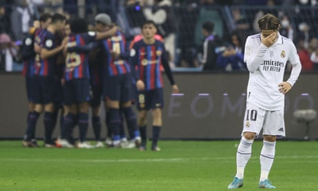 Luka Modric looks distraught as Barcelona celebrate a goal during the Spanish Super Cup final against Real Madrid.