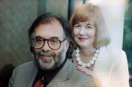 A middle-aged white couple with shaggy hair smiling.