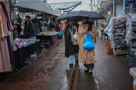 People shopping in the rain at Longsight Market on February 11, 2026 in Manchester, United Kingdom.