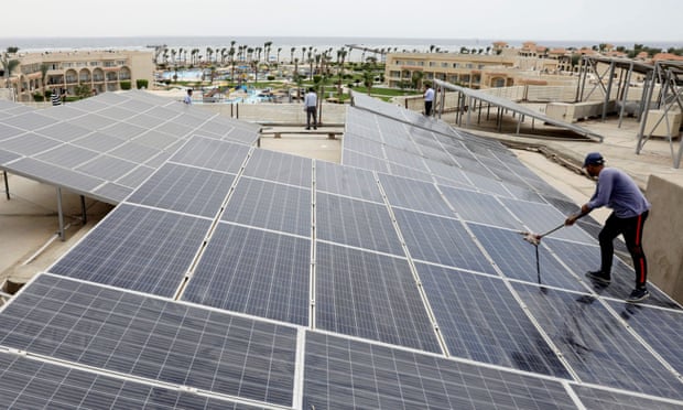 A man cleans solar cells on a rooftop of a hotel in Egypt's resort town of Sharm el-Sheikh, where the Cop27 summit is due to take place in November
