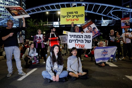 People hold signs during a demonstration held to demand the liberation of hostages who are being held in the Gaza Strip in Tel Aviv, Israel.