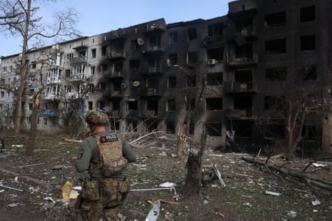 A Ukrainian police officer walks past a destroyed residential building in Ocheretyne. Russian forces have now reportedly entered the village.