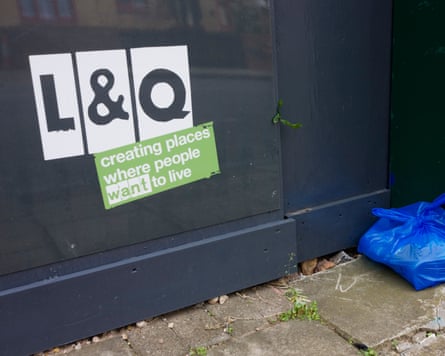 A plastic shopping bag containing what appears to be waste is dumped next to a sign for the London housing association company L&Q that says residents will want to live and be happy