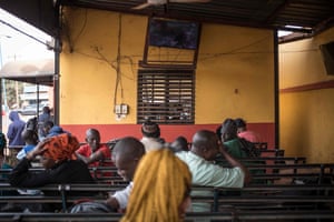 Travellers watch television whilst waiting for cross border transport to resume in Bamako.