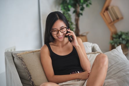 Happy woman talking on the phone, sitting on a couch