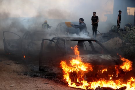 Men attempt to put out a fire on a car that was set on fire by Israeli settlers during a raid on the village of al-Mughayyir on Friday.