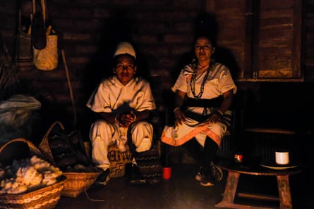 Two people sit in a darkened room