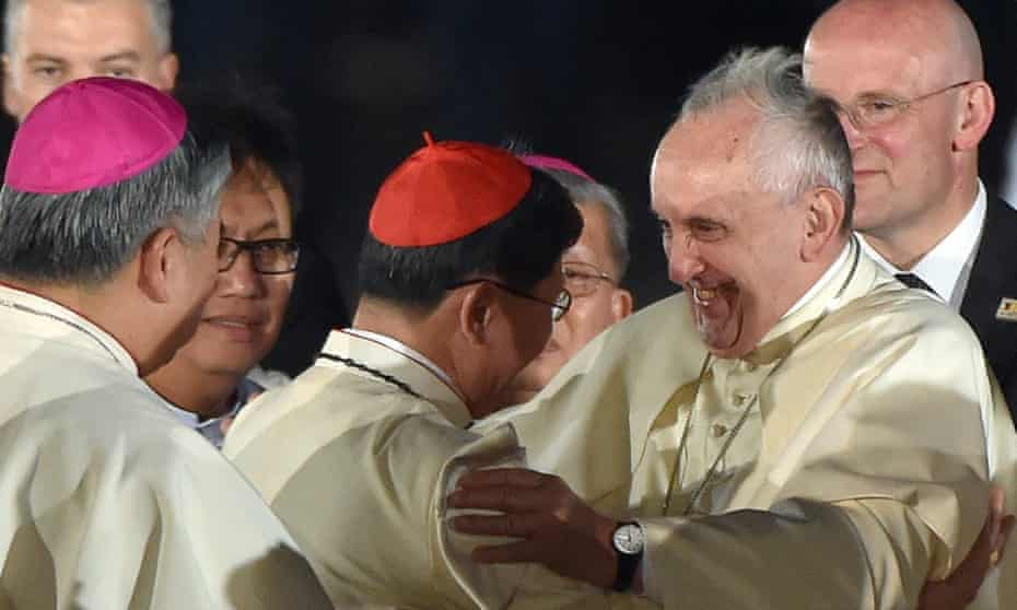 Pope Francis (centre right) embraces Philippine Cardinal Luis Antonio Tagle (centre) at Villamor Air Base in Manila, Philippines