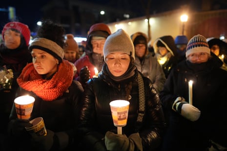 People hold candles at vigil
