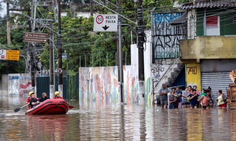 Residents walk in the middle of a flooded street after heavy rains in Sao Paulo, Brazil.