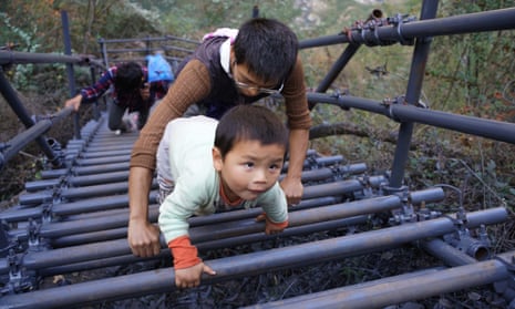 Children climb steel cliff ladders to get in and out of village in Sichuan province, China. 