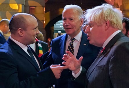Naftali Bennett chats to Joe Biden and Boris Johnson in a conference hall
