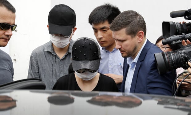 Unidentified Crown Resorts employees wearing face masks are escorted by security as they leave the Baoshan District People’s Court after the trial on Monday.