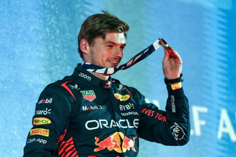 Verstappen holds up his medal on the podium.