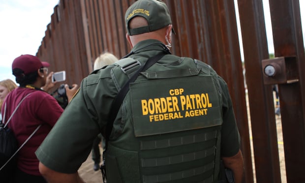 A US border patrol agent keeps watch  on the US-Mexico border