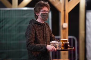 Bar staff at the Switch bar in Newcastle serve drinks ordered through an app by customers shortly after midnight following the easing of lockdown measures on April 12, 2021 in Newcastle Upon Tyne, England.