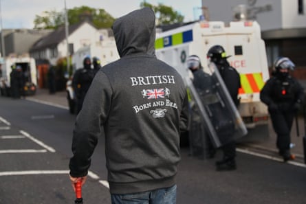 Police in riot gear watch protesters in Belfast, Northern Ireland