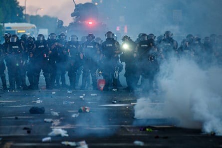 Police in riot gear block a road in Minneapolis.