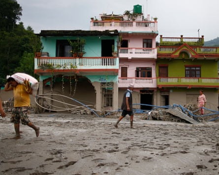 People gather their belongings from their homes on to a truck in a flood-affected area.