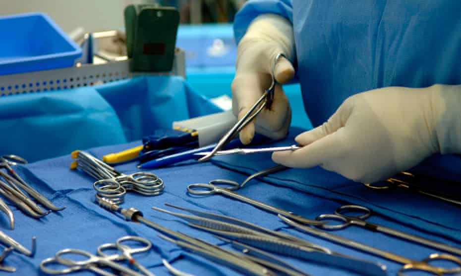 A medical worker prepares surgical tools in an operating theatre