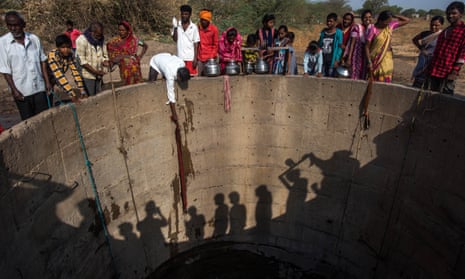 Villagers from Nandi village in Jaina, India, fill muddy water from the well.