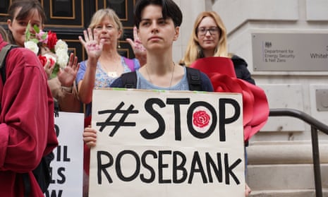 People stand behind a person holding a sign saying Stop Rosebank