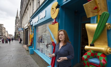 Shona McCarthy, the chief executive of the fringe, leans against a colourful shop front in Edinburgh
