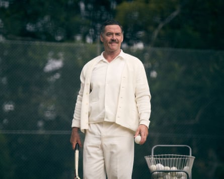 a man standing next to a basket of tennis balls wearing all white