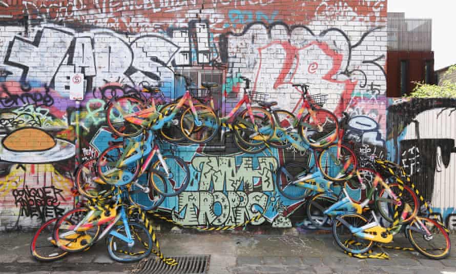 An unknown artist creates mural in a lane way in Melbourne, Australia from dockless bikes.