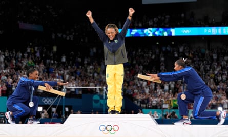 Simone Biles (left) and Jordan Chiles (right), both from the US, bow to gold medallist Rebeca Andrade from Brazil, during the medal ceremony for the women’s artistic gymnastics individual floor finals.