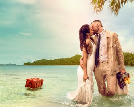 Press image of a couple kissing in shallow waters in front of an idyllic island