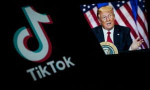 A close-up shows the TikTok sharing application on a smartphone with Donald Trump in the background.
