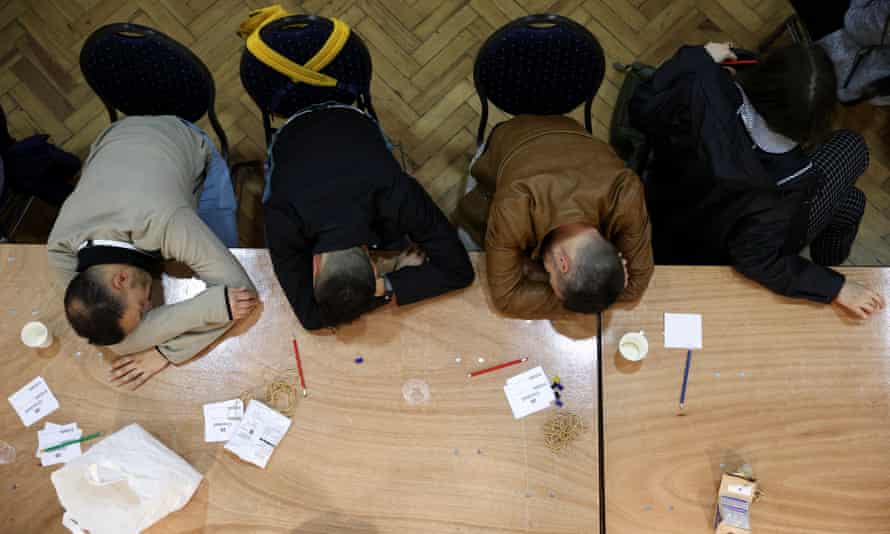 Members of the counting staff rest during the counting process at the Westminster city council local elections, at Lindley Hall