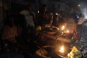At another Lagos market, vegetable vendors ply their wares by the light of locally-made lanterns.