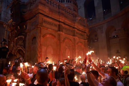 مسیحیان ارتدکس با شمع های روشن در اطراف Edicule که به طور سنتی معتقدند محل دفن عیسی مسیح است، در طی مراسم آتش مقدس جمع می شوند.