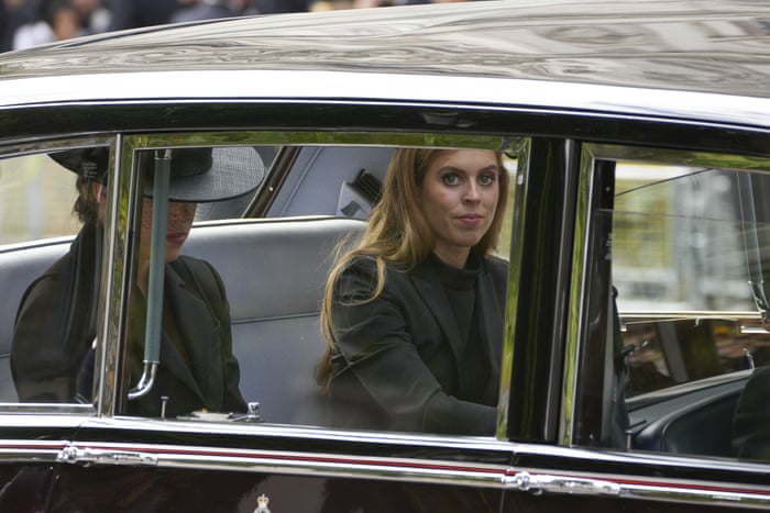Princess Eugenie and Princess Beatrice sit in a car following the coffin of Queen Elizabeth II.