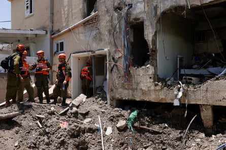 Israeli soldiers and first responders check the damage caused to a building from an Iranian strike in Beit She’an