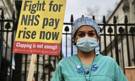 An NHS nurse protests outside Downing street during a demonstration about the 1% pay rise for staff.