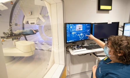 doctor looking at hospital computer next to machinery