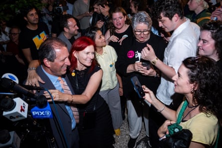 a man smiles as supporters surround him