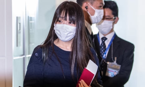 Japan’s former princess Mako Komuro and her husband Kei Komuro walk to the departure gate for their flight to New York  on Sunday
