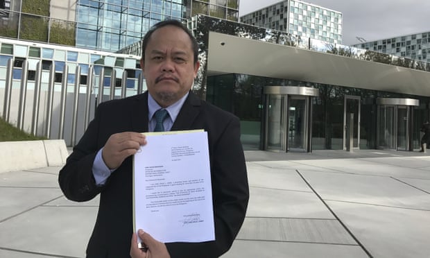 Lawyer Jude Sabio from the Philippines poses for a portrait as he holds a 77-page file outside the International Criminal Court in The Hague.