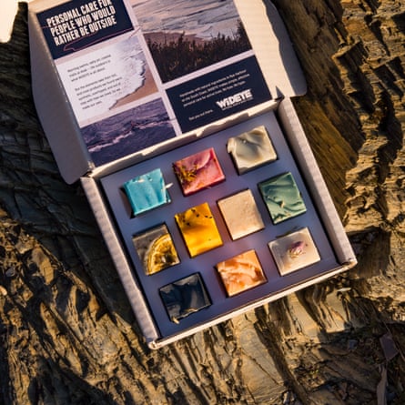 Box of 10 square WiDEYE shower bars resting on a rugged rock