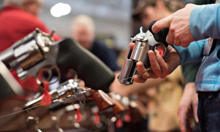 An attendee handles a revolver in the Sturm Ruger booth on the exhibition floor of the NRA’s annual meeting in Nashville.