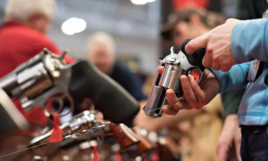 An attendee handles a revolver in the Sturm Ruger booth on the exhibition floor of an NRA meeting.