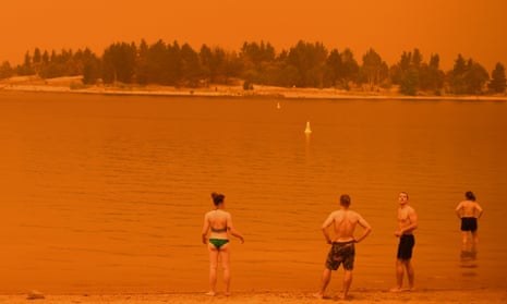 Residents take a dip to cool down at Lake Jindabyne under a red sky due to smoke from bushfires, in the town of Jindabyne in New South Wales on 4 January 2020.