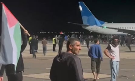 A from video footage shows protesters with a Palestinian flag invading the runway of Makhachkala airport